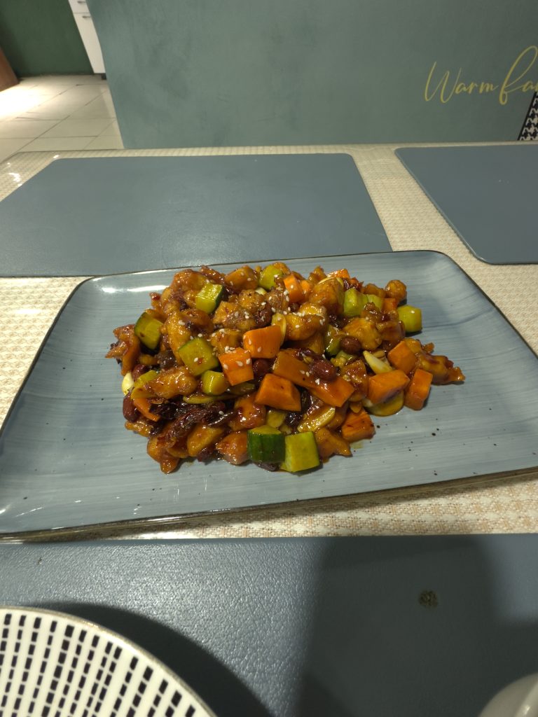 Plate of Kung Pao Chicken with peanuts, dried chilies, and bell peppers from a Chinese restaurant in Sergeli, Tashkent.