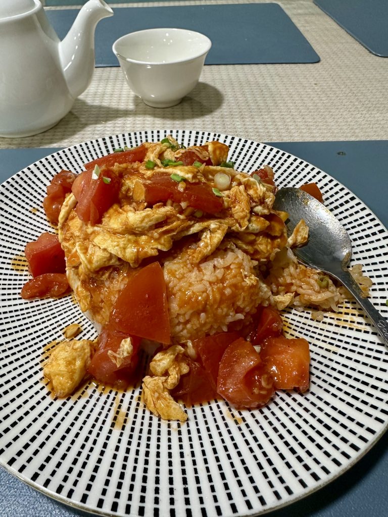 Bowl of Tomato Egg over Rice with fluffy eggs and tangy tomato sauce from a Chinese restaurant in Sergeli, Tashkent.